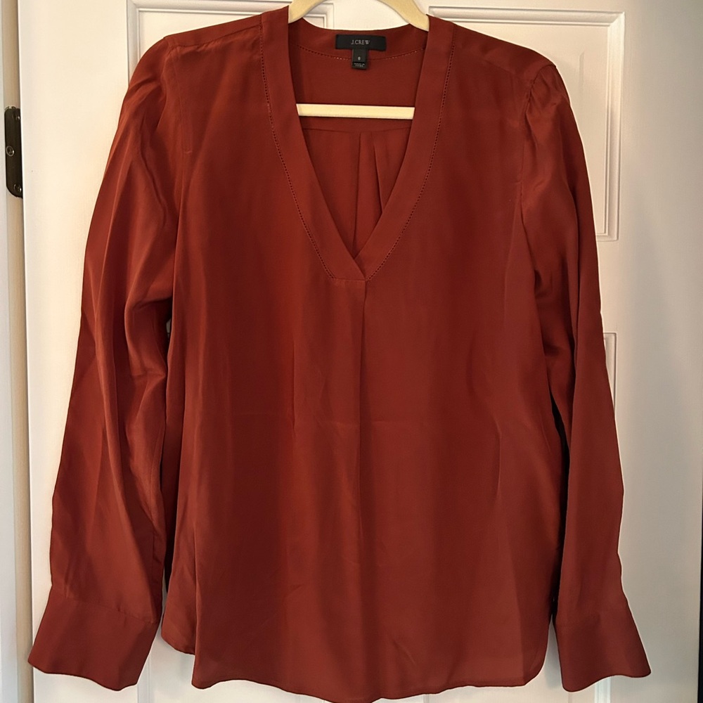 Jcrew rust colored vneck silk blouse with hemstitch.  Size 8